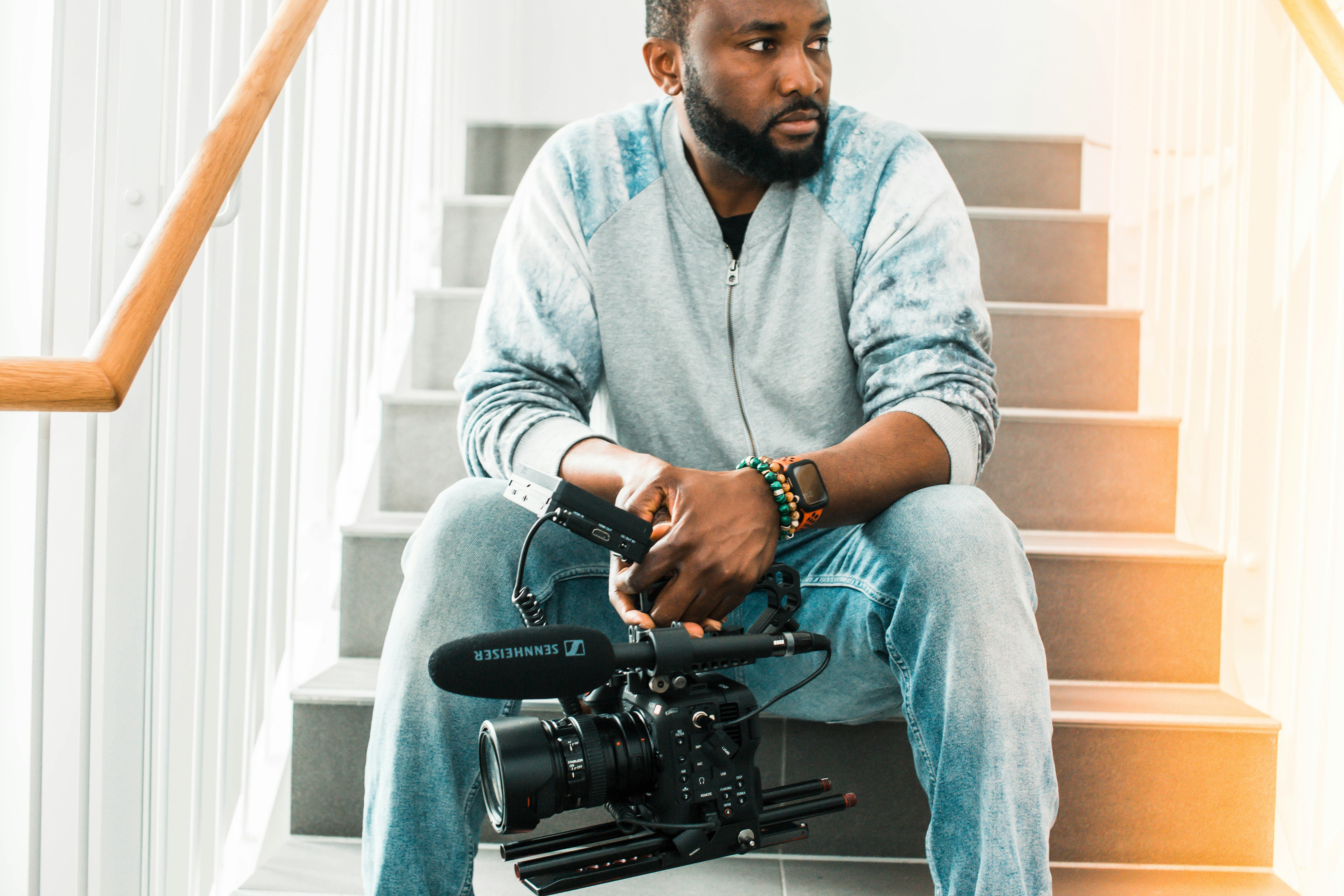 man in gray sweater and blue denim jeans sitting on stairs